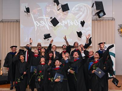 The Korntal graduates celebrate while flanked by CIU Interim President Dr. 里克·克里斯特曼和教务长博士. 詹姆斯Lanpher. 